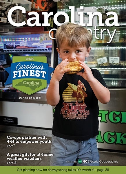 November Carolina Country Cover - Young boy enjoys a pastry from the Scratchmade Snackary in Hatteras Village NC