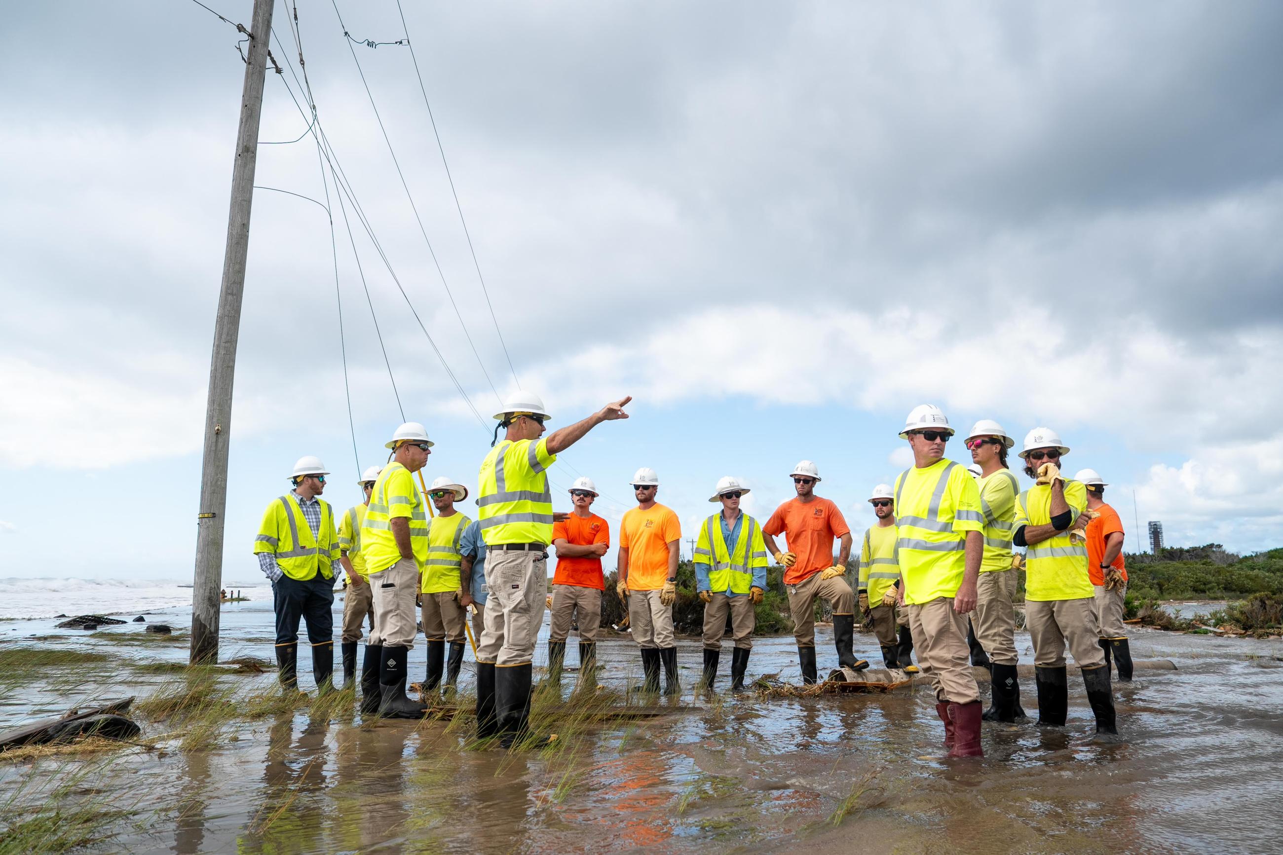 CHEC Linemen on jobsite in flooded beach 